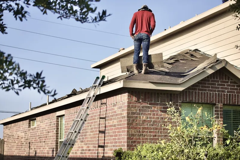 Professional roofer working on a residential roof in Luxomni